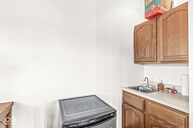 kitchen featuring brown cabinets, light countertops, and a sink