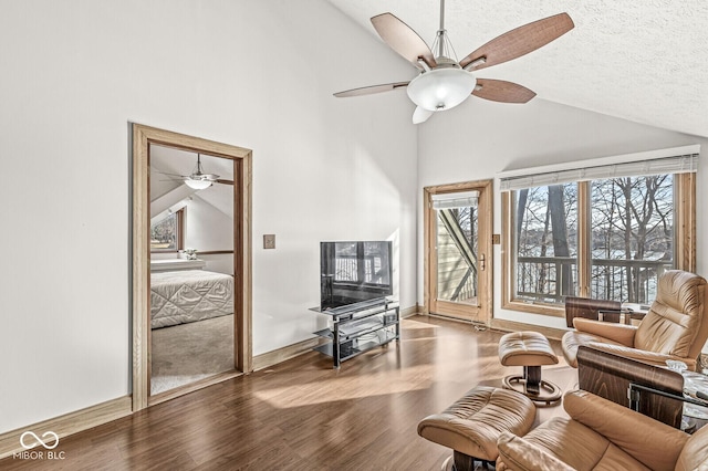 living area featuring a textured ceiling, high vaulted ceiling, wood finished floors, a ceiling fan, and baseboards