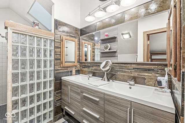 bathroom with tile walls, double vanity, lofted ceiling, a sink, and walk in shower