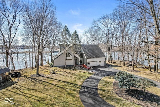 view of front of property featuring an attached garage, aphalt driveway, and a front yard