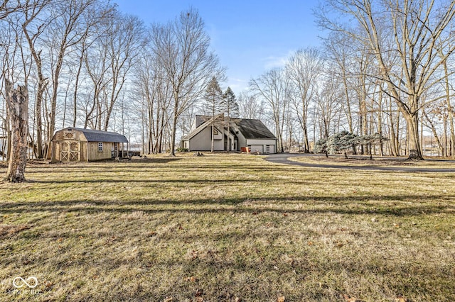 view of yard featuring an outbuilding, a storage unit, and a detached garage