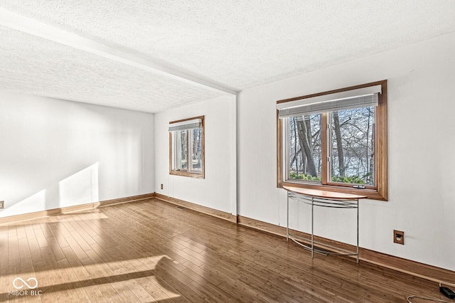 empty room featuring hardwood / wood-style flooring and a textured ceiling