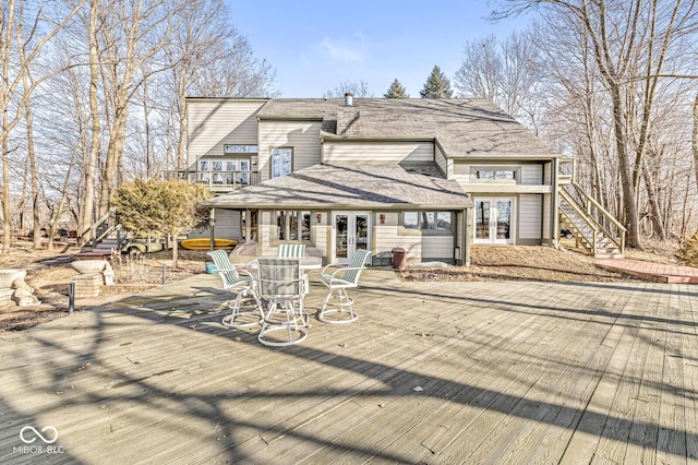 exterior space featuring a wooden deck, stairway, roof with shingles, and french doors