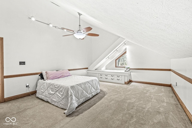 carpeted bedroom with a ceiling fan, lofted ceiling, a textured ceiling, and baseboards