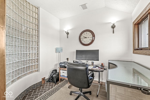 office space with vaulted ceiling and a textured ceiling