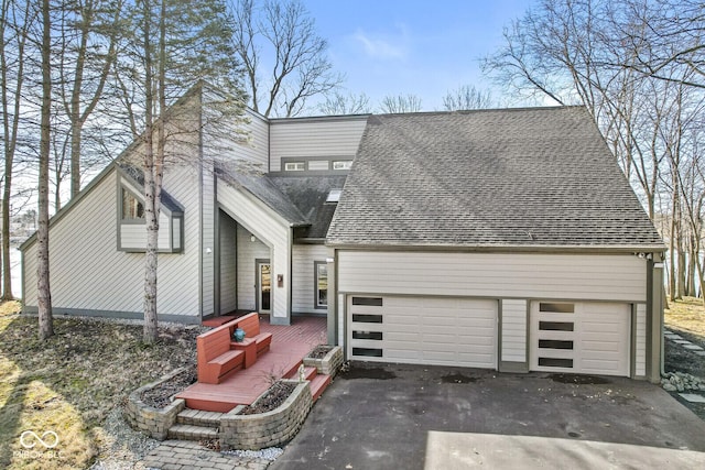 view of front of house with driveway and roof with shingles