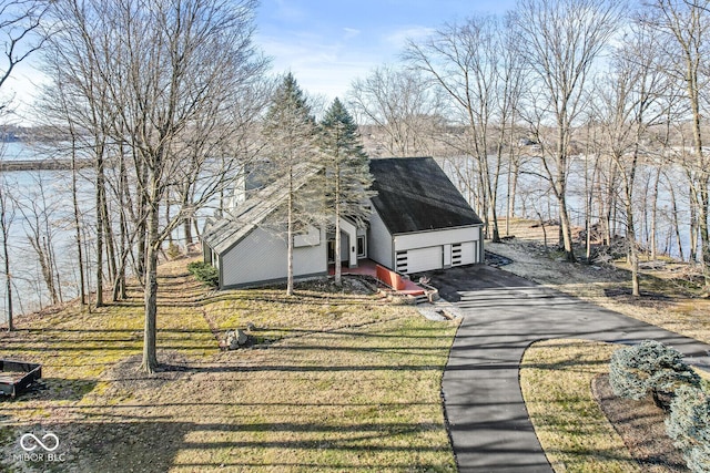 view of front facade with aphalt driveway and roof with shingles