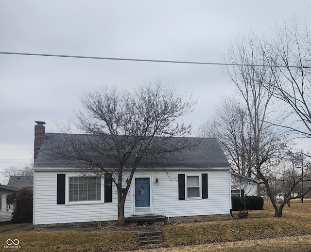 view of front of house featuring a chimney and a shingled roof