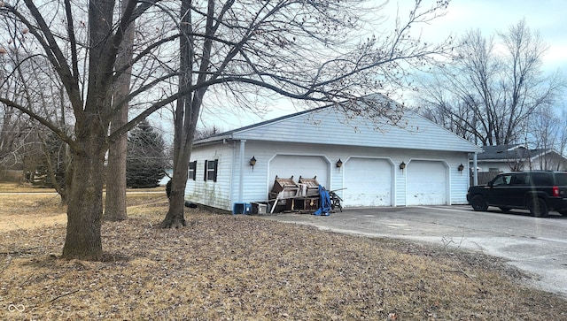 exterior space with a garage, an outbuilding, and concrete driveway