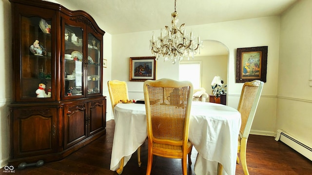 dining area with a baseboard heating unit, dark wood-style floors, arched walkways, and a chandelier