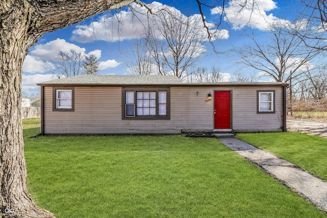 view of front of house with a front yard and roof with shingles