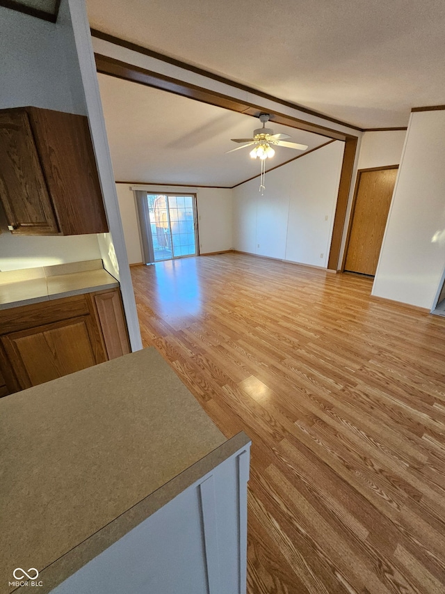 unfurnished living room featuring light wood-type flooring, a ceiling fan, and lofted ceiling