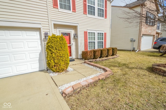 view of exterior entry with a garage and a yard