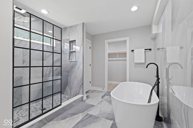 full bathroom featuring a walk in shower, recessed lighting, a freestanding bath, marble finish floor, and a spacious closet