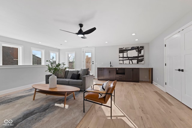 living room with a ceiling fan, light wood-type flooring, baseboards, and recessed lighting