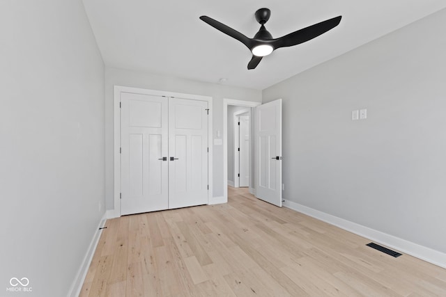 unfurnished bedroom with ceiling fan, light wood-style flooring, visible vents, baseboards, and a closet