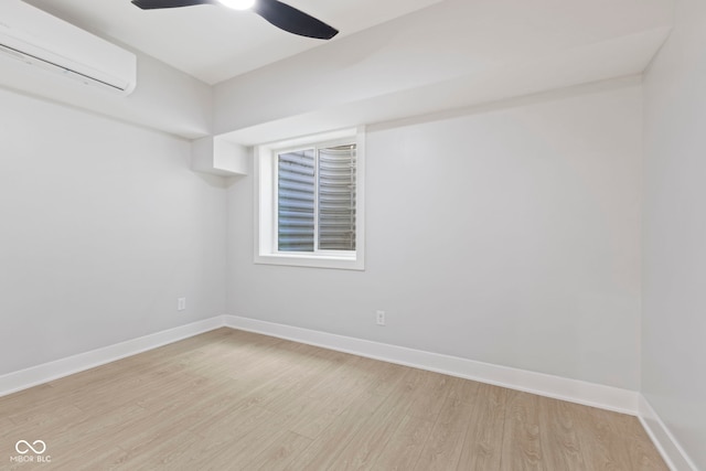 unfurnished room featuring light wood-type flooring, an AC wall unit, ceiling fan, and baseboards