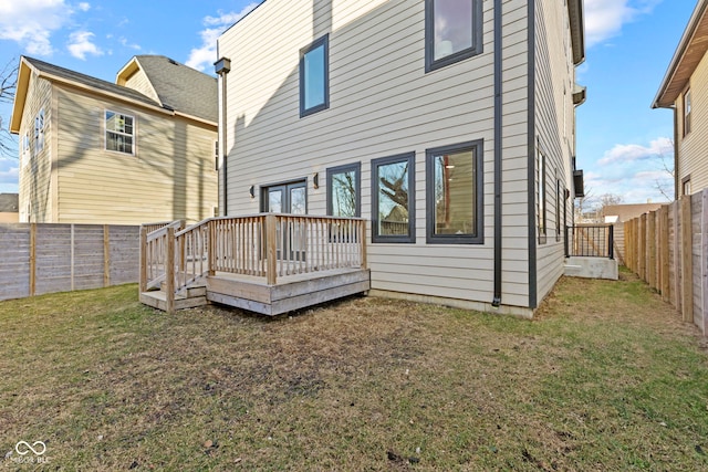 back of house featuring a fenced backyard, a lawn, and a wooden deck