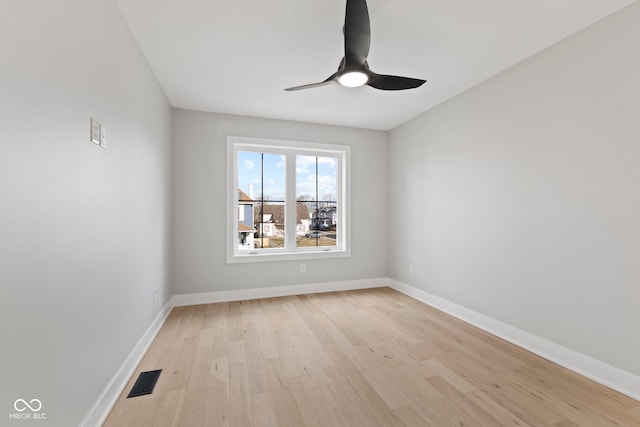 empty room with light wood finished floors, visible vents, baseboards, and a ceiling fan