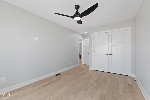 unfurnished bedroom featuring a ceiling fan, visible vents, baseboards, a closet, and light wood finished floors