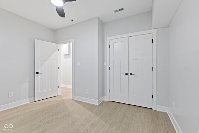 unfurnished bedroom with a closet, visible vents, light wood-style flooring, ceiling fan, and baseboards