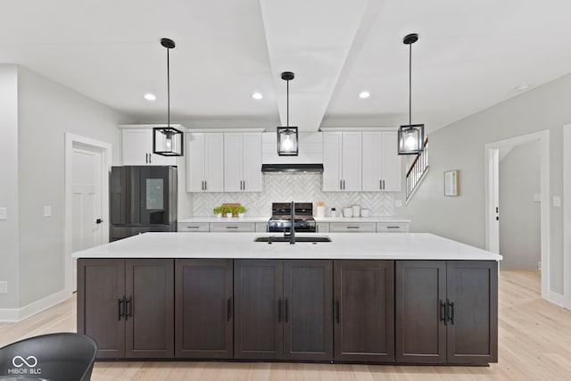 kitchen with smart refrigerator, white cabinetry, light countertops, and a sink