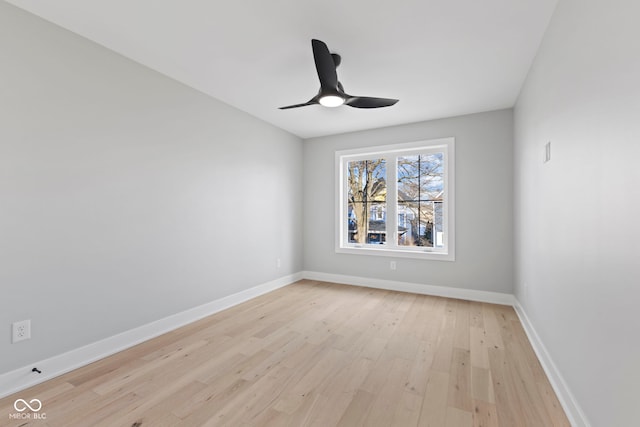 spare room featuring light wood finished floors, baseboards, and a ceiling fan