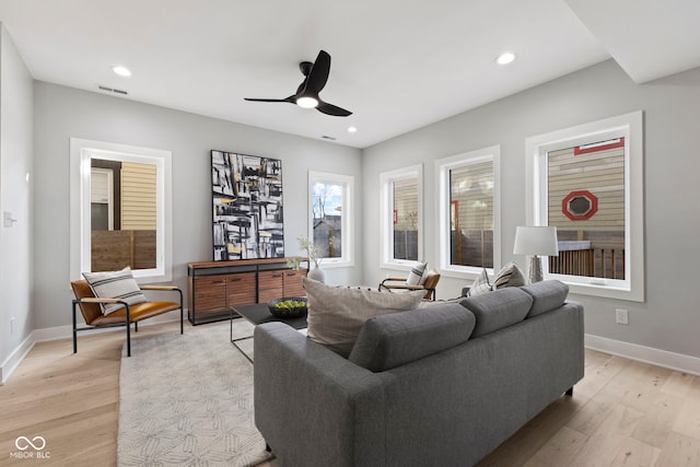 living area featuring light wood-style floors, baseboards, and recessed lighting