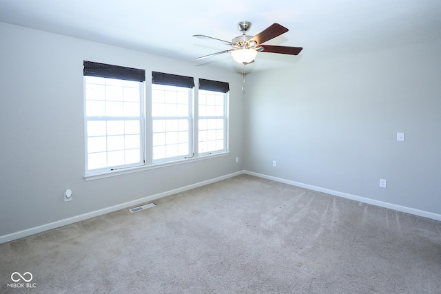 unfurnished room with a ceiling fan, carpet, visible vents, and baseboards