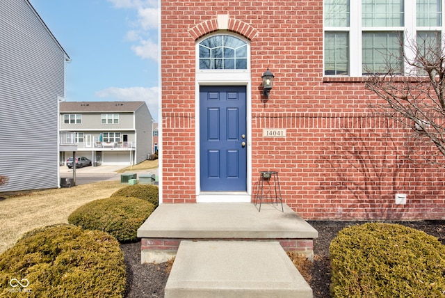 view of exterior entry featuring brick siding