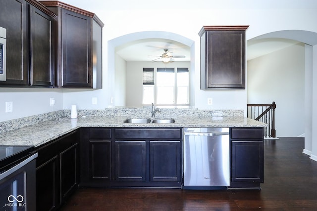 kitchen featuring dark wood finished floors, ceiling fan, light stone counters, stainless steel dishwasher, and a sink