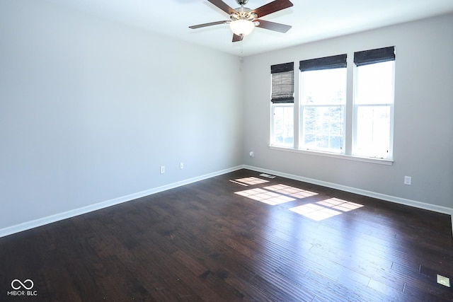 empty room with a ceiling fan, baseboards, and wood finished floors