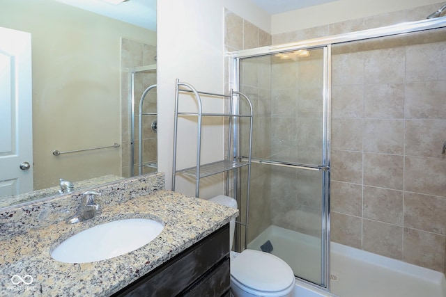 bathroom featuring a stall shower, vanity, and toilet