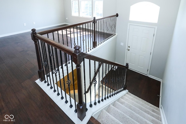 staircase featuring baseboards and wood finished floors