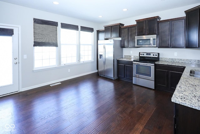 kitchen with recessed lighting, stainless steel appliances, dark wood-type flooring, visible vents, and light stone countertops