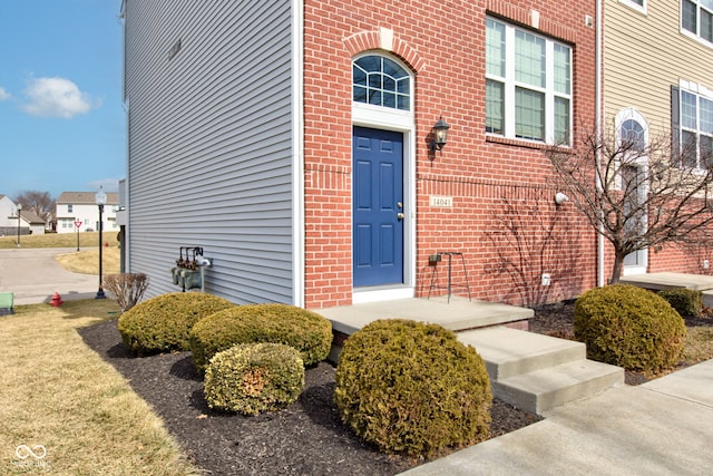 doorway to property with brick siding