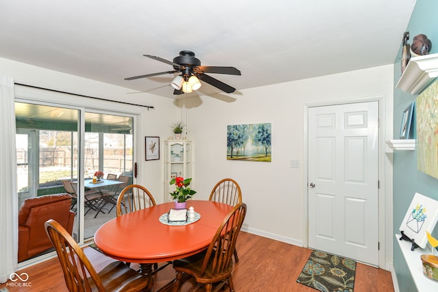 dining room featuring wood finished floors, a ceiling fan, and baseboards