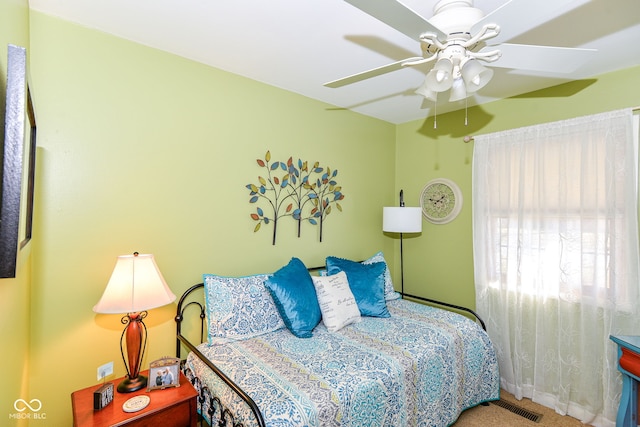 carpeted bedroom with visible vents and a ceiling fan