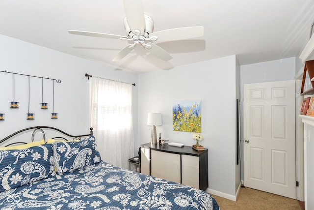 carpeted bedroom with ceiling fan and baseboards