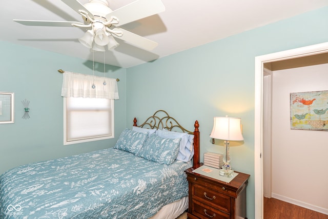 bedroom featuring ceiling fan, baseboards, and wood finished floors