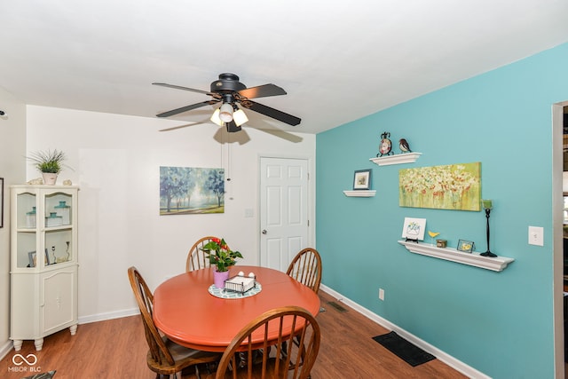 dining area featuring baseboards, visible vents, and wood finished floors