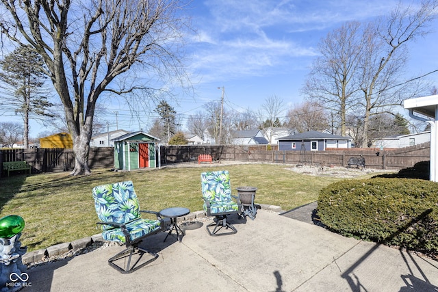 view of patio featuring an outbuilding, a storage unit, and a fenced backyard