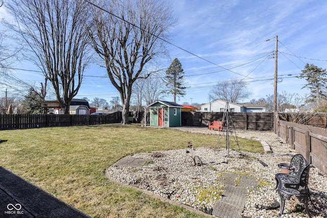 view of yard featuring an outbuilding, a fenced backyard, and a storage unit