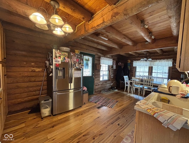 kitchen featuring wooden ceiling, stainless steel fridge, a chandelier, and log walls