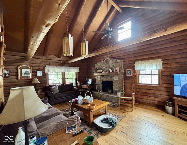 living area with plenty of natural light, beam ceiling, a fireplace, and hardwood / wood-style flooring