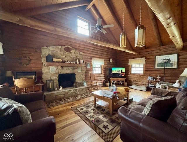 living area featuring hardwood / wood-style flooring, plenty of natural light, a fireplace, and beam ceiling