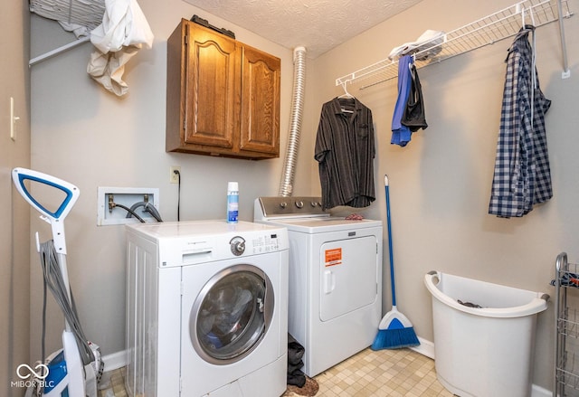 washroom with cabinet space, a textured ceiling, baseboards, and separate washer and dryer