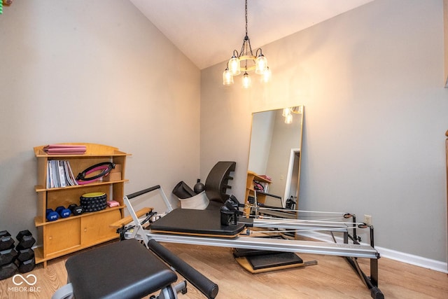 workout room with lofted ceiling, wood finished floors, and baseboards