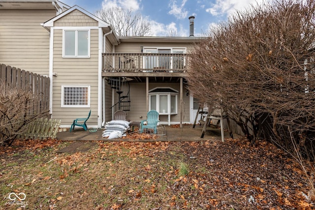 rear view of house with a patio, a deck, and fence