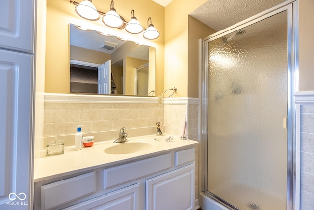 full bath featuring visible vents, a shower stall, vanity, and tile walls